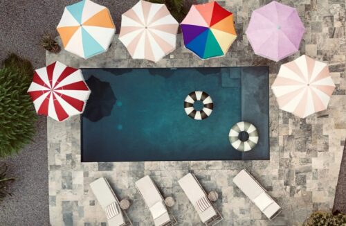 Parasoll från Monchiqe i olika färger vid en pool